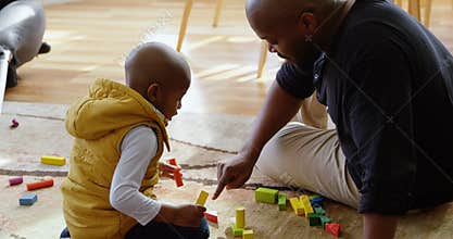 Father and son playing with building blocks in a comfortable home 4k