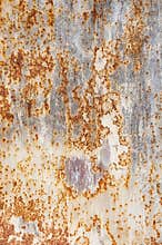Background texture of old rusty damaged metal. Remains of multi-colored paint on an iron sheet