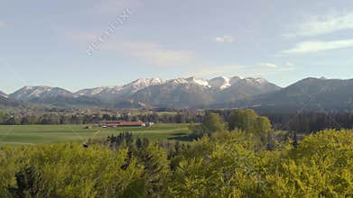 Flight over forest and beautiful Bavarian landscape with alps
