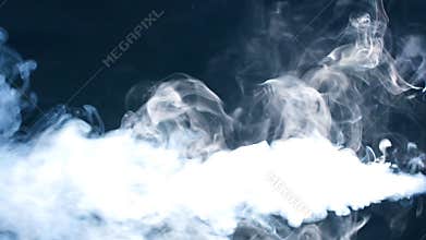 Smoke on black background in blue light.