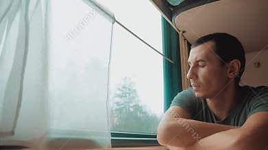Man travel rides train railway looks out the window. Traveler concept train lifestyle railroad journey travel. Slow