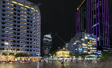 Night view on pedestrian street with wide path along the skyscrapers many lights