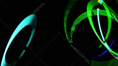 Rotation of luminous rings in the dark. Fast rotation of LED rings. Circus show