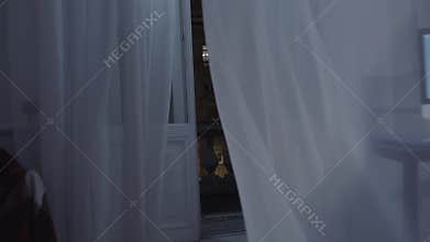 Night city street balcony dolly to room, man writing script on computer