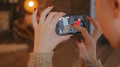 Woman using smartphone with augmented reality app and placing furniture in room
