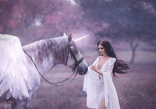 Beautiful, young elf, walking with a unicorn. She is wearing an incredible light, white dress. Art hotography