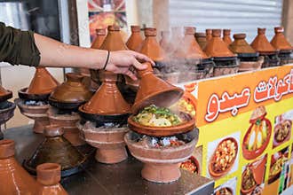Preparing food in tajin traditional dish in Morocco - meat and v