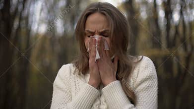 Lady sneezing and blowing her nose into napkin, seasonal allergies, epidemic