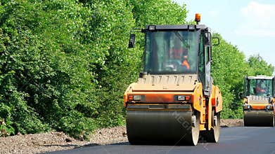 Repair of a highway, roller compactor machine , asphalt finisher laying a new fresh asphalt pavement, covering on one