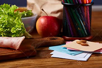 Back to School concept, school supplies, biscuits, packed lunch and lunchbox on white desk, selective focus, close-up.
