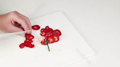 Hands Slicing Red Jalapeno with a Knife