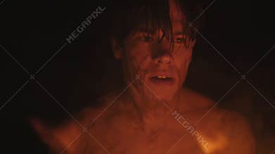 The anchorite with burning torch in hand looking around in dark cave