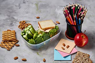 Back to School concept, school supplies, biscuits, packed lunch and lunchbox over white chalkboard, selective focus.