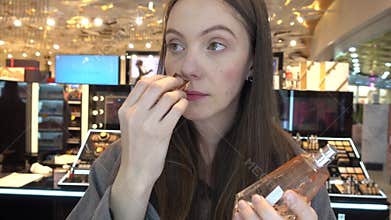 Girl sniffing pleasant perfume smell beauty store