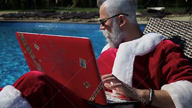 Santa relax at pool and do crazy joke with laptop