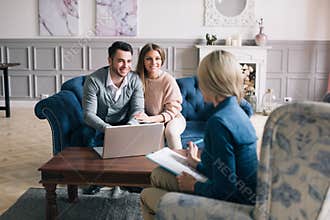 Successful agent giving consultation to family couple about buying house.