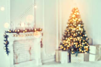 Holiday decorated room with Christmas tree and decoration, background with blurred, sparking, glowing light.