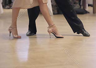 Graceful dance couple tangoing at the ballroom.