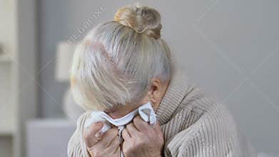 Lonely abandoned depressed elderly woman crying desperately in nursing home
