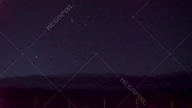 Dark night in the mountains. Flashing stars