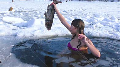 Woman in the hole is holding a fish.
