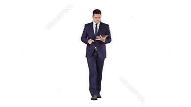 Man in suit walking and using digital tablet on white background.
