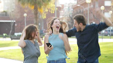 Excited friends jumping after checking phone content