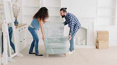 Young couple moving furniture new apartment