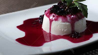 Footage of a panna cotta cake on a white plate, the shot is moving from the left side to the right