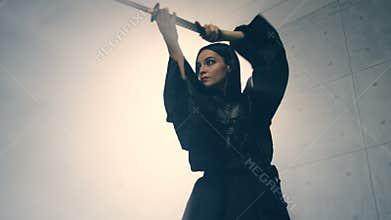 Woman in kimono practicing martial arts with katana