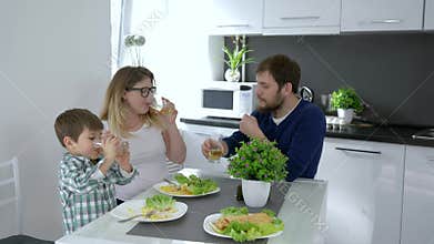 Good parents, cheerful family clinking with drinks in hand during breakfast