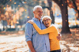 Seniors on a walk in autumn forest