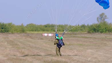 Skydiver gliding from the sky to the land, extreme jump.
