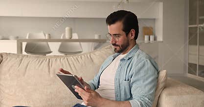Happy young 30s man using digital computer tablet.