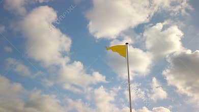 Yellow triangle flag indicating medium hazard, at a beach in France