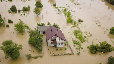 Aerial view of flooded house with dirty water all around it.