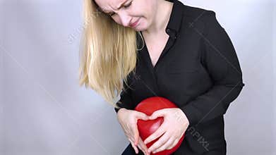Bloating and flatulence concept. The woman holds a red balloon near the abdomen, which symbolizes bloating. Intestinal tract and d
