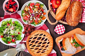 Summer picnic food table scene above view over a wood background.