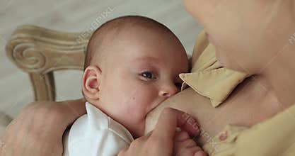 Mother breastfeeding newborn baby, close up view