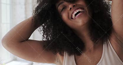 A happy, cheerful young mixed-race woman dancing alone