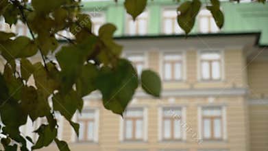 Hotel or apartment beige building with a green roof in the city.