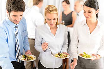 Business colleagues serve themselves at buffet
