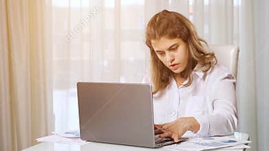 Disabled woman freelancer works on laptop from home at table