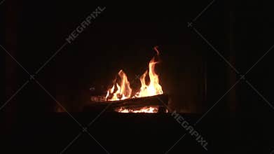 Burning fireplace with wooden logs and flame inside. New Year and Christmas winter holiday background, warmth and home comfort