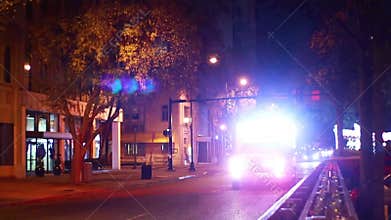 Ambulance passing by with sirens at night downtown