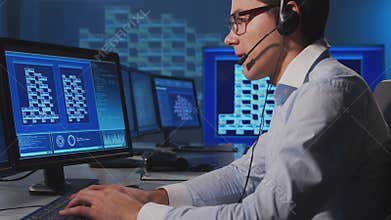 Call-center worker is speaking with the client by headset. Workplace of the support operator.