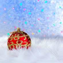 Christmas bauble on white fur and lights