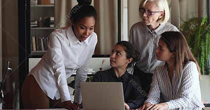Multiethnic businesswomen listen to African project leader at workplace