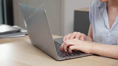 Young caucasian woman sitting and using laptop computer planning for success in modern office.