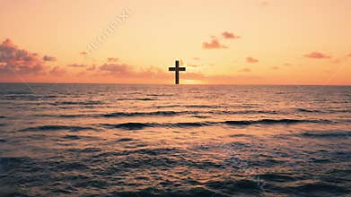 Silhouette of Christian cross in the ocean at sunset
